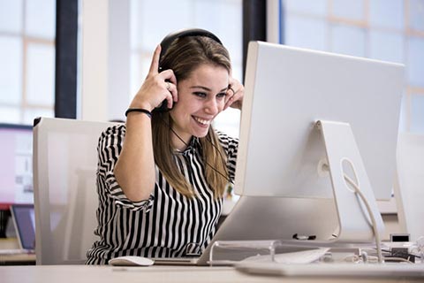 person wearing headset at computer in office setting