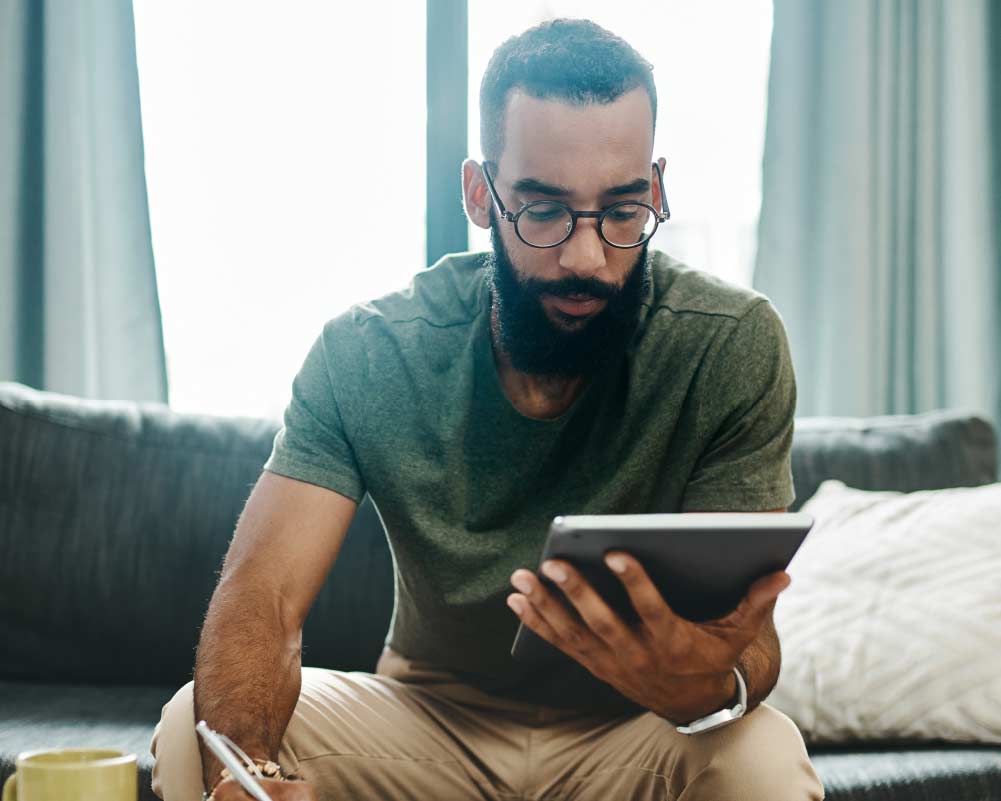 A man looking at business data on his tablet.