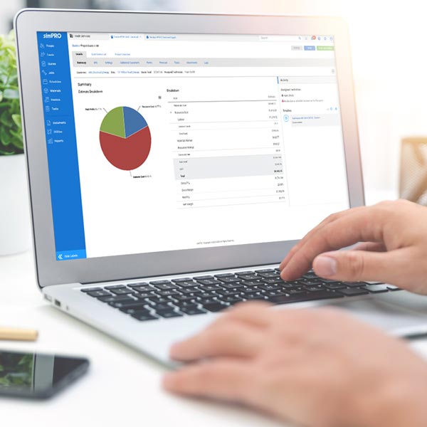 A project manager using Simpro project features on a laptop.