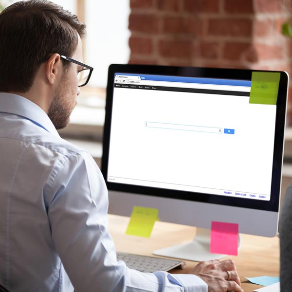 A man searching for information in a cloud-based software system on his desktop