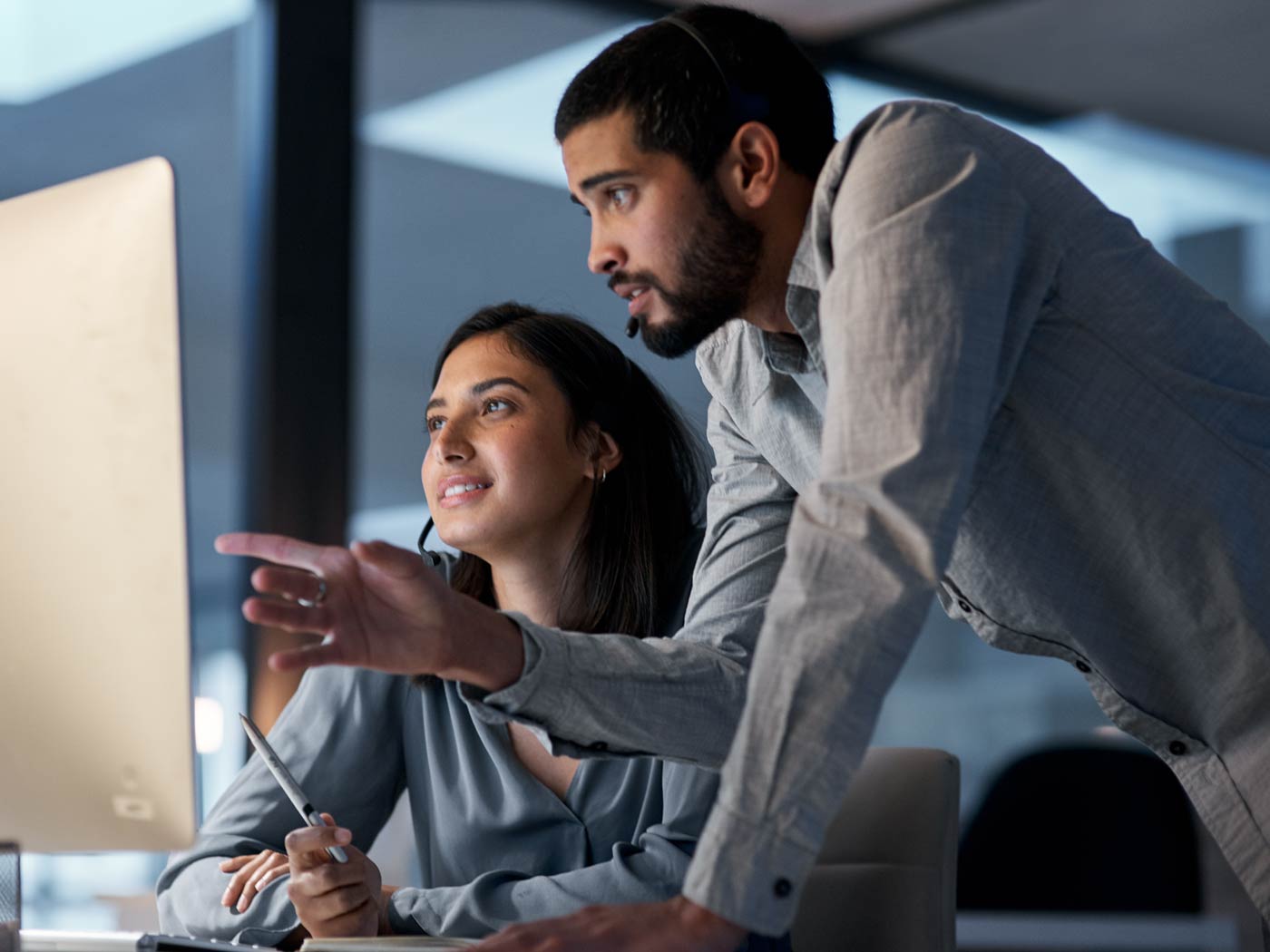 Office workers looking at computer screen and conversing