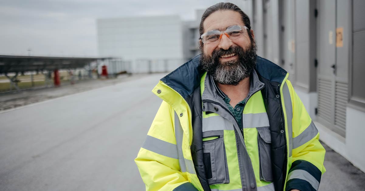 Smiling electrical contractor in yellow reflective vest