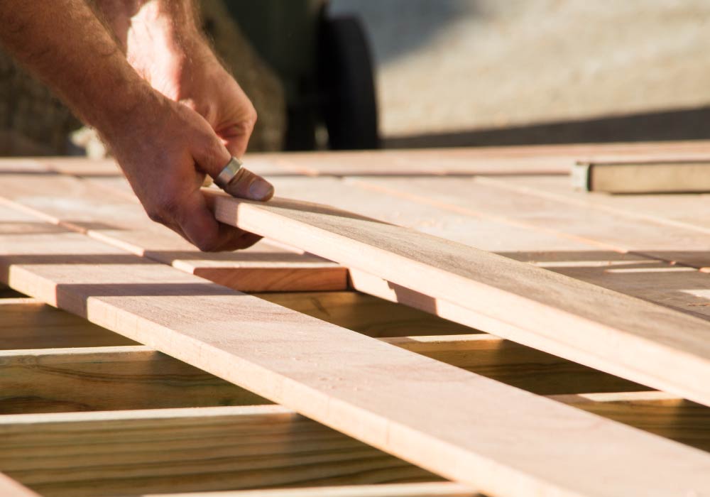 Two hands can be seen working with wood