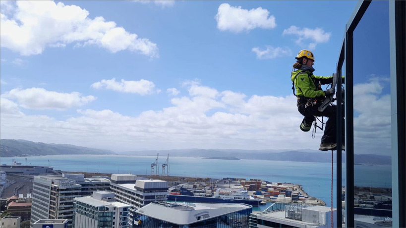 person working on the outside of a tall building