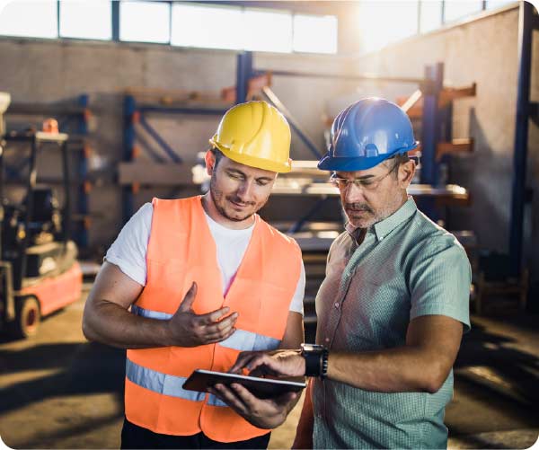 2 workers in PPE using tablet device