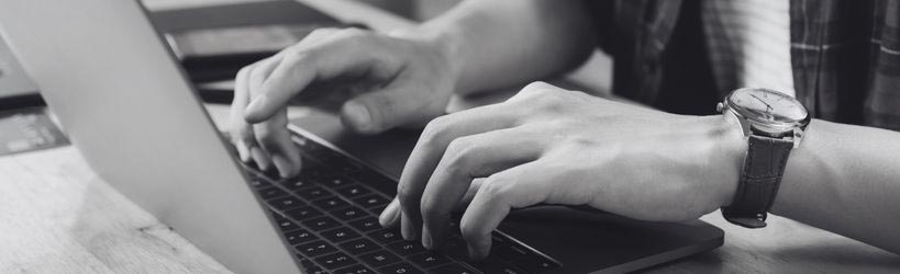 hands typing on notebook computer