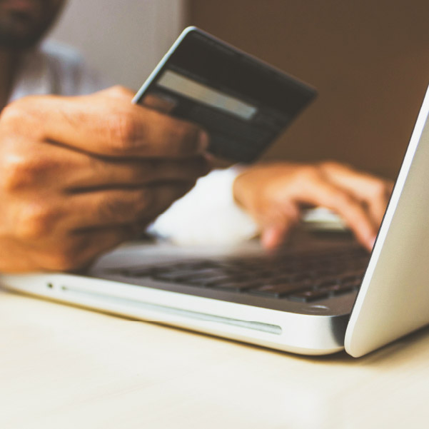 User operating a laptop, making a purchase with a credit card