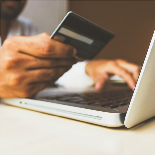 User holding credit card, making an online purchase with a laptop.