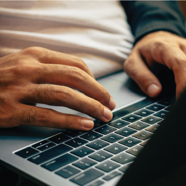 Close up of user's hands operating a laptop.