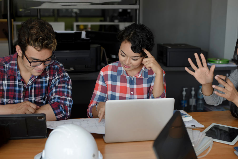 Man and woman in front of computer looking at spreadsheets