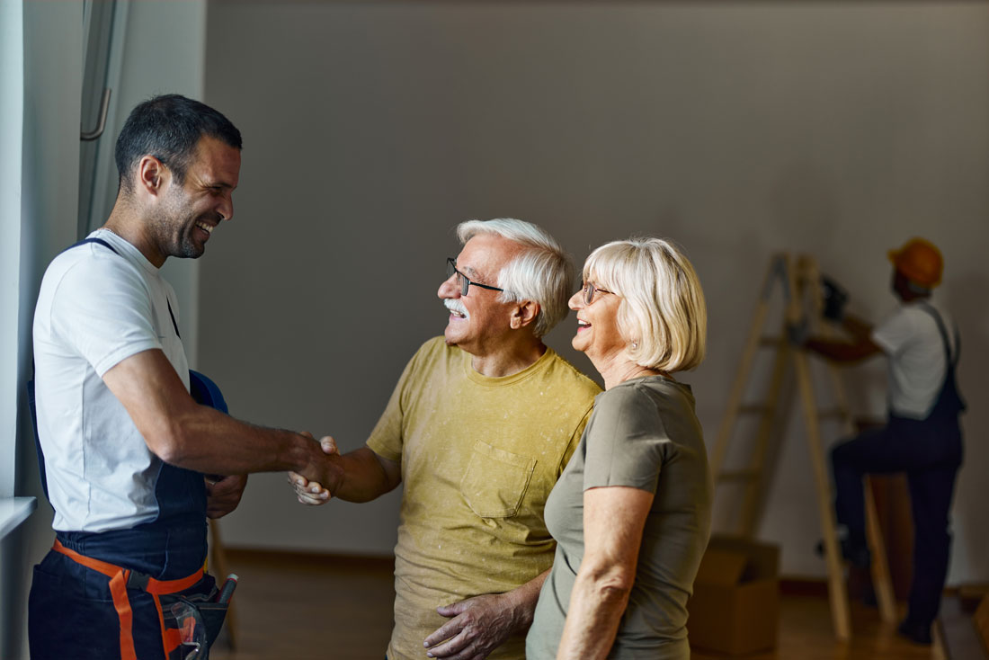 Couple thanking man in white t-shirt for completing job