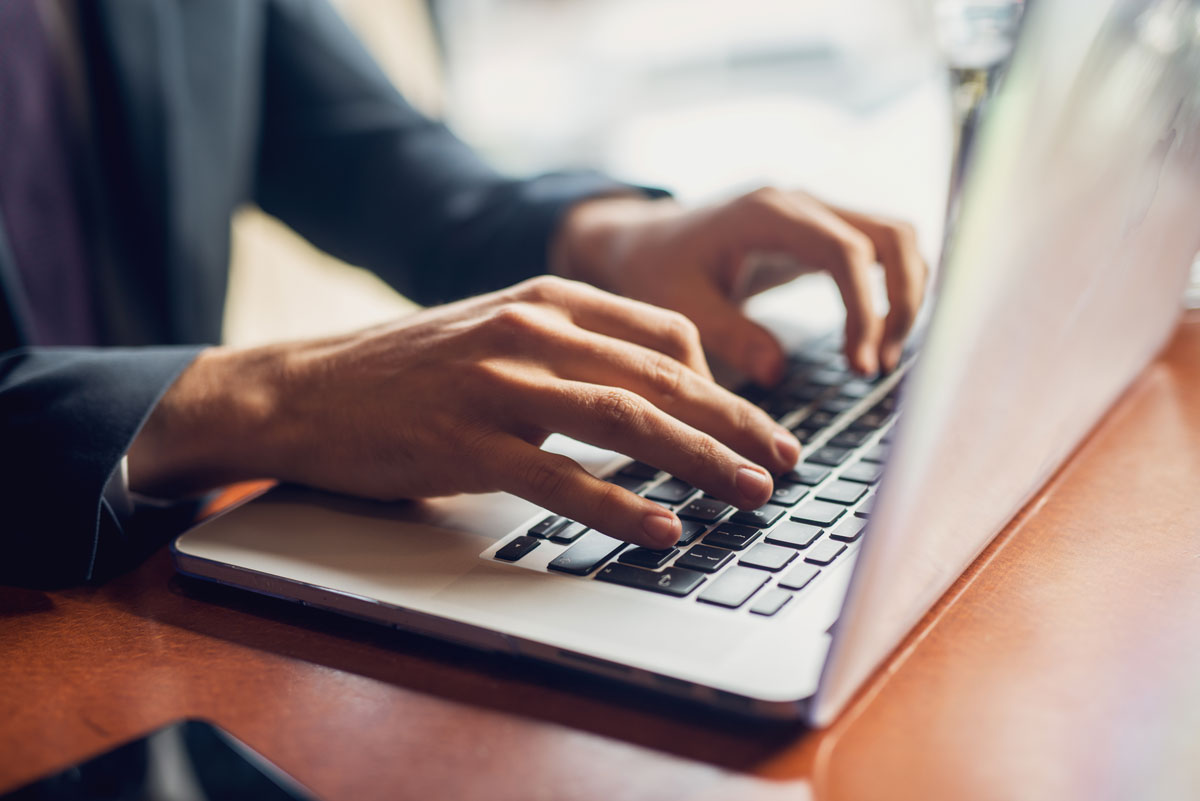 Hands typing on a computer