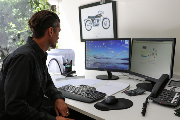 ADJ Electrical Construction Manager, Raynor Pierce, sitting at a computer desk