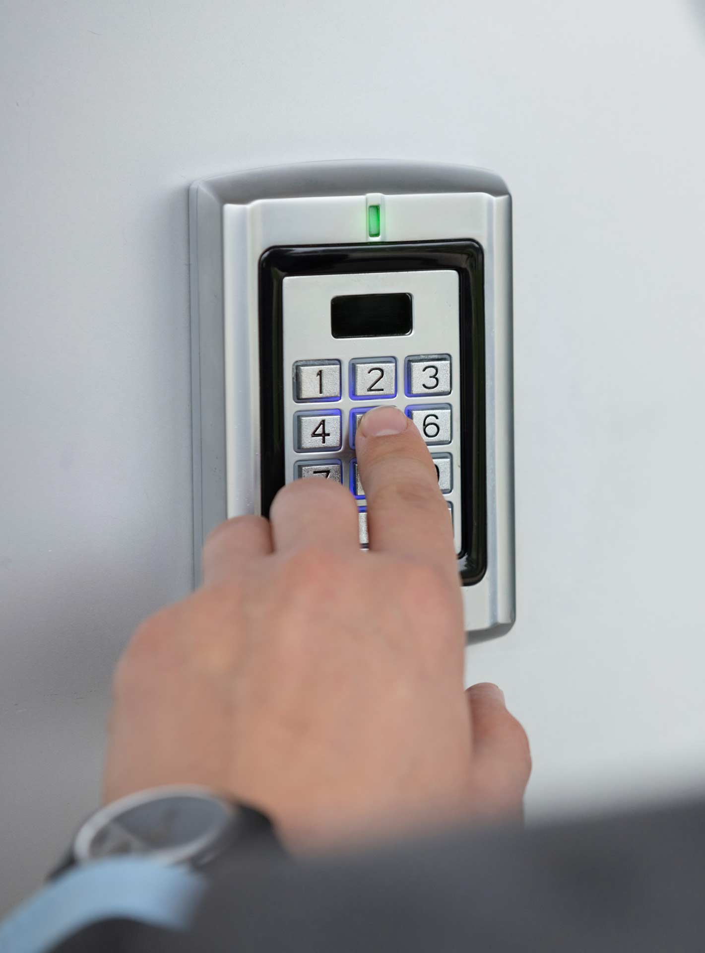 A man enters a pin on door security device