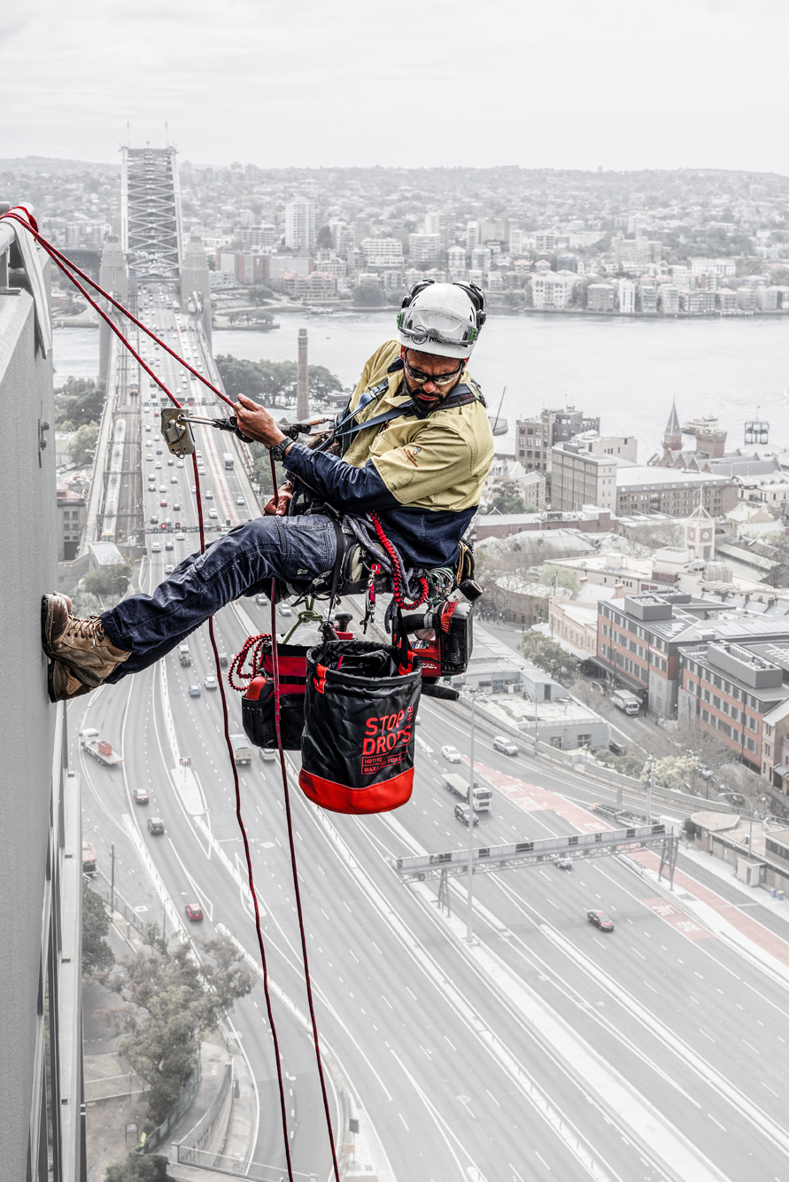 Sky5 worker in a harness, scaling down the side of a tall building