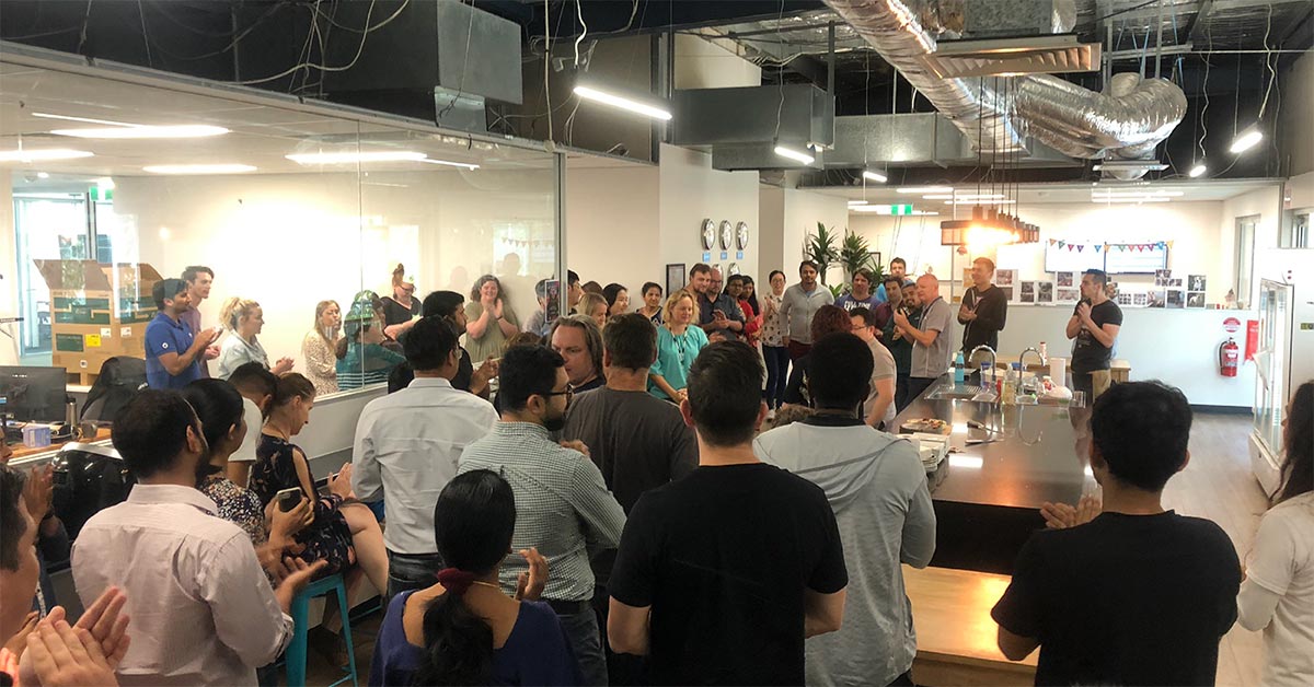 Crowd celebrates with Rick Lan at 10 year anniversary of working at Simpro