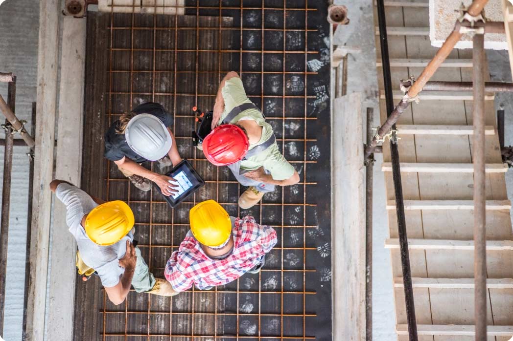 birdseye view of workers at job site using tablet device